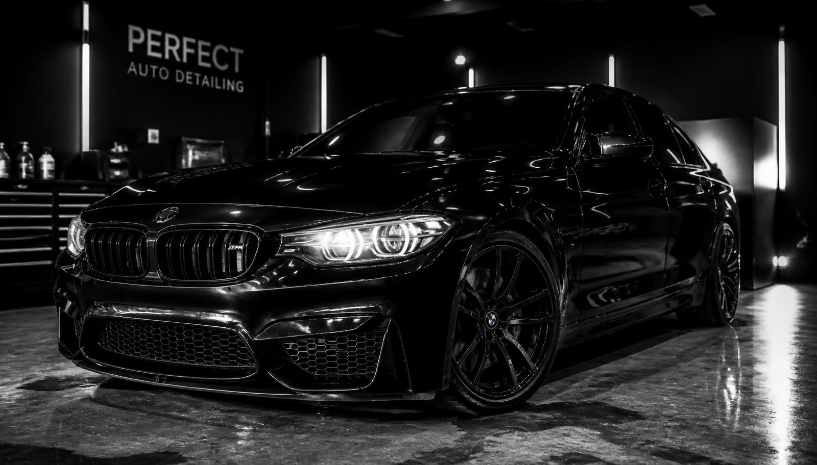 Freshly detailed glossy black sedan with a mirror paint finish